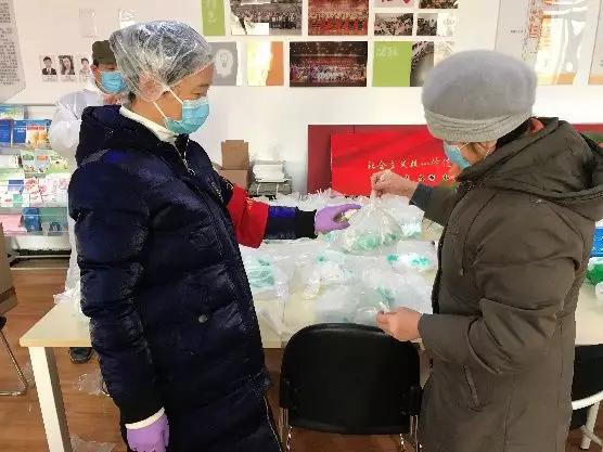 為樓棟分發(fā)口罩，并為包裝袋消毒